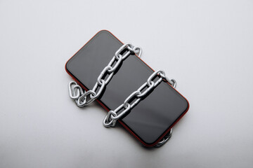 Modern smartphone with chain locked on a white table