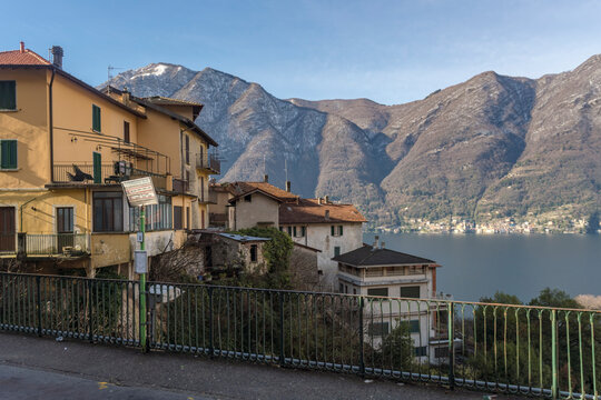 Italy, Como, Houses by lake Como with Alps in background