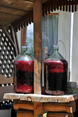 Making red homemade wine. A  glass bottles with a must with an a