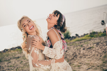 Photo of two funny crazy ladies enjoy embrace laugh wear casual outfit nature seaside beach outdoors