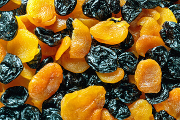 Background of mixed dried apricots and black prunes