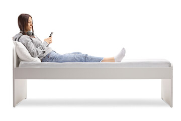 Feemale teenager lying on a bed and using a smartphone