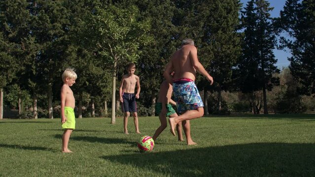A man with children plays ball on the lawn during the summer holidays. A fun active pastime. IT, Borgagne, 8.10.2021 