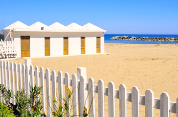 Cabine bianche di cemento sulla spiaggia vicino al mare durante la primavera