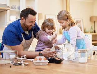 The kitchen is the heart of the home. Shot of a young father baking together while a little girl stirs a bowl of cake batter.