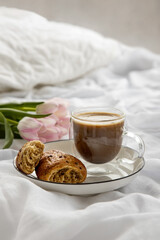 Romantic morning cup of coffee with a croissant in a bedroom.