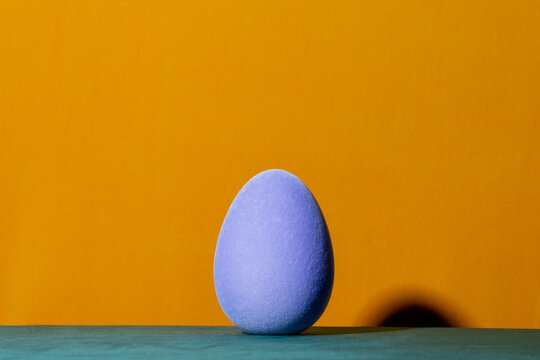 Soft blue Easter egg decoration on yellow background