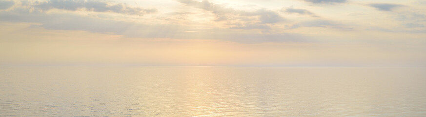 Baltic sea shore (sand dunes) at sunset. Clear blue sky and golden sunlight, reflections in a still...
