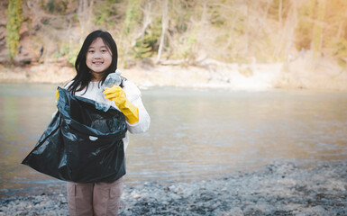 Earth Day concept, girl teens pick up garbage in litter bags, clean-ups in nature to recycling in...