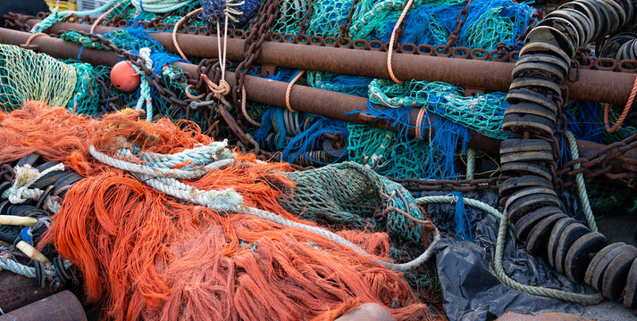Fishing nets, floats and trawler equipment in harbor