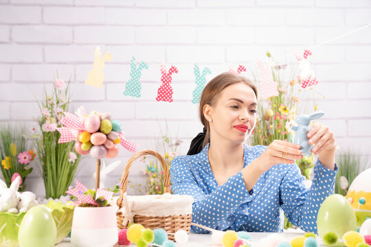 Pretty young women  preparing easter decorations.  Easter background. Bouquets of spring flowers. Easter eggs in baskets.