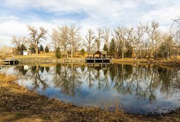 Beautiful early spring landscape with a pond and reflections in the small neighborhood Fly'n B Park in Highland Ranch, Colorado