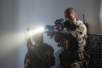 Alert military men during battle. Caucasian men with beards with smears of blood on face aiming...