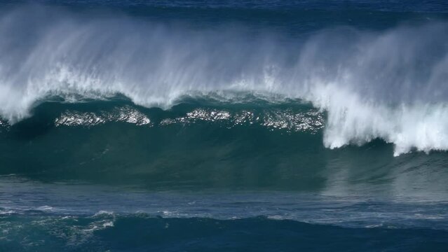 super slow motion shot of giant wave breaking at the beach coastline of portugal