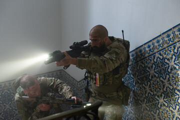 Attentive military men during battle. Caucasian men with beards with smears of blood on face aiming...
