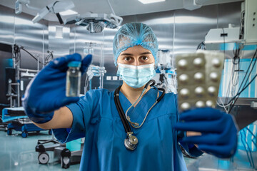 Female doctor in blue uniform, mask and gloves holding stethoscope  and .demonstrating pills