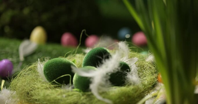Easter eggs in basket, feathers falling down. Easter eggs and feathers in a basket spinning on an Easter background.