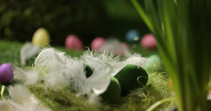 Easter eggs in basket, feathers falling down. Easter eggs and feathers in a basket spinning on an Easter background.