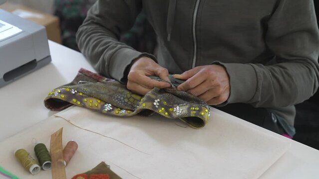 This video shows a seamstress working on a custom swimsuit top, ripping the seams with her tools.