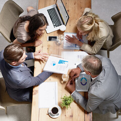 Looking through ways to build their business. High angle shot of a group of businesspeople having a discussion in an office.