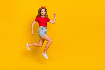 Fototapeta na wymiar Full body photo of cute teenager girl run wear t-shirt hairband skirt shoes isolated on yellow background
