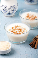 Creamy rice pudding in bowls. Creamy rice pudding topped with cinnamon on blue background.