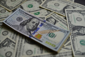 Currency war concept, Global economic crisis situation. A heap of one hundred dollar bills on The US currency notes. Shallow depth of field. Selective focus.