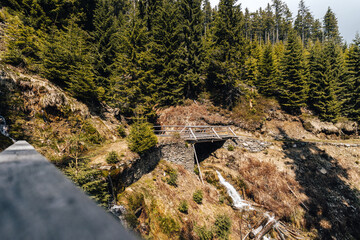 Mountain stream with a wooden bridge in Krkonose National park, Czechia. Mountain creek in Giant Mountains, Bohemia.