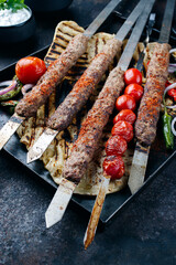Traditional Turk Adana kebap on shashlik skewer with barbecue vegetable and flatbread served as...
