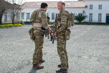 Portrait of brave soldiers after battle. Men with blood smears on faces standing near house, resting. Military, army, teamwork, fighting, airsoft concept