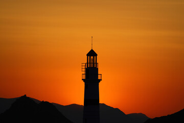 Seascape at sunshine. Lighthouse and sailings on the coast. Seaside town of Turgutreis and spectacular sunshine	
