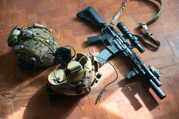 Close-up of machine gun and equipment lying on floor. Weapon, helmet and bullets lying on table. Military, army, airsoft concept