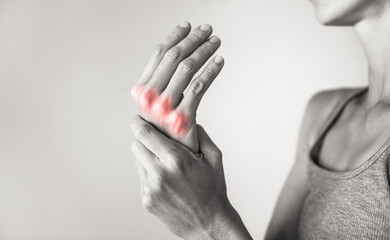 Woman suffering from pain in hands and fingers, arthritis inflammation. Red highlight - obrazy, fototapety, plakaty