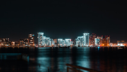 Obraz na płótnie Canvas Panoramic view of Kazan city waterfront illuminated skyscrapers. New residential neighborhoods on the river bank in Kazan