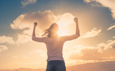 People will power concept. Strong woman with arms flexed up to the sunrise.