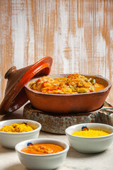 Grouper moqueca served with saffron rice, farofa and pirão and pepper sauce. Typical Brazilian food