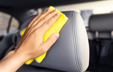 Person cleaning detailing leather car seat.  