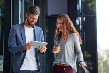 Collaboration is essential to every business. Cropped shot of two young creatives working together on a digital tablet outside.