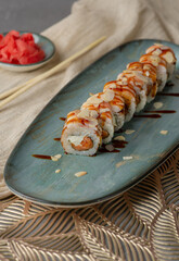 Uramaki rolls with red fish and garnish on a gray background