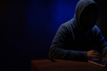 Hacker man working laptop computer. Hacker attack in dark room
