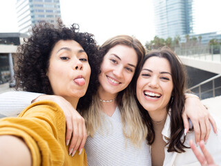 Three multiethnic young female friends having fun in the city.