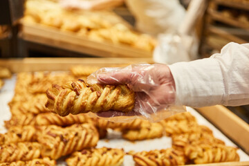 Hand of customer packs puff pastry snack in plastic bag