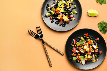 Plates of tasty Mexican vegetable salad with black beans and radish on color background