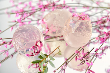 Ice with fresh pink flowers on light background