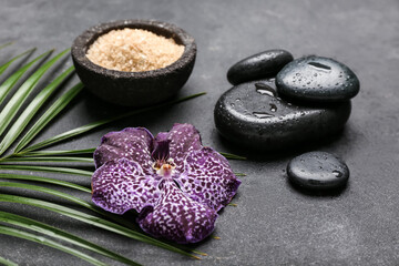Fototapeta na wymiar Orchid flower with sea salt and spa stones on dark background