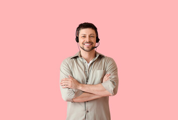 Smiling consultant of call center in headset on pink background
