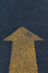 Yellow arrow painted on asphalt forward. Concept of moving forward