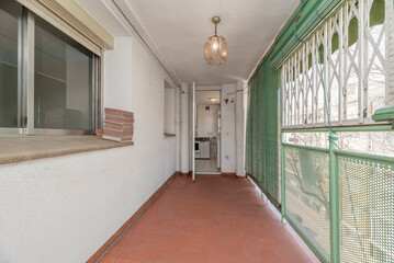 Terrace with green railing, rolled green wooden shutters and access to the kitchen