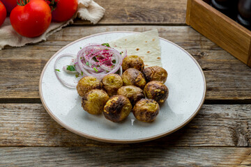 baked mini potatoes with red onion on old wooden table