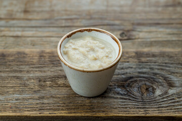 horseradish sauce in a saucepan on old wooden table
